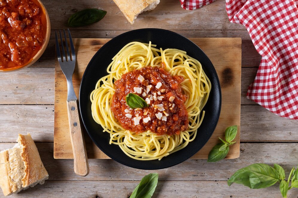 Spaghetti Bolognese servită cu un pahar de vin roșu italian