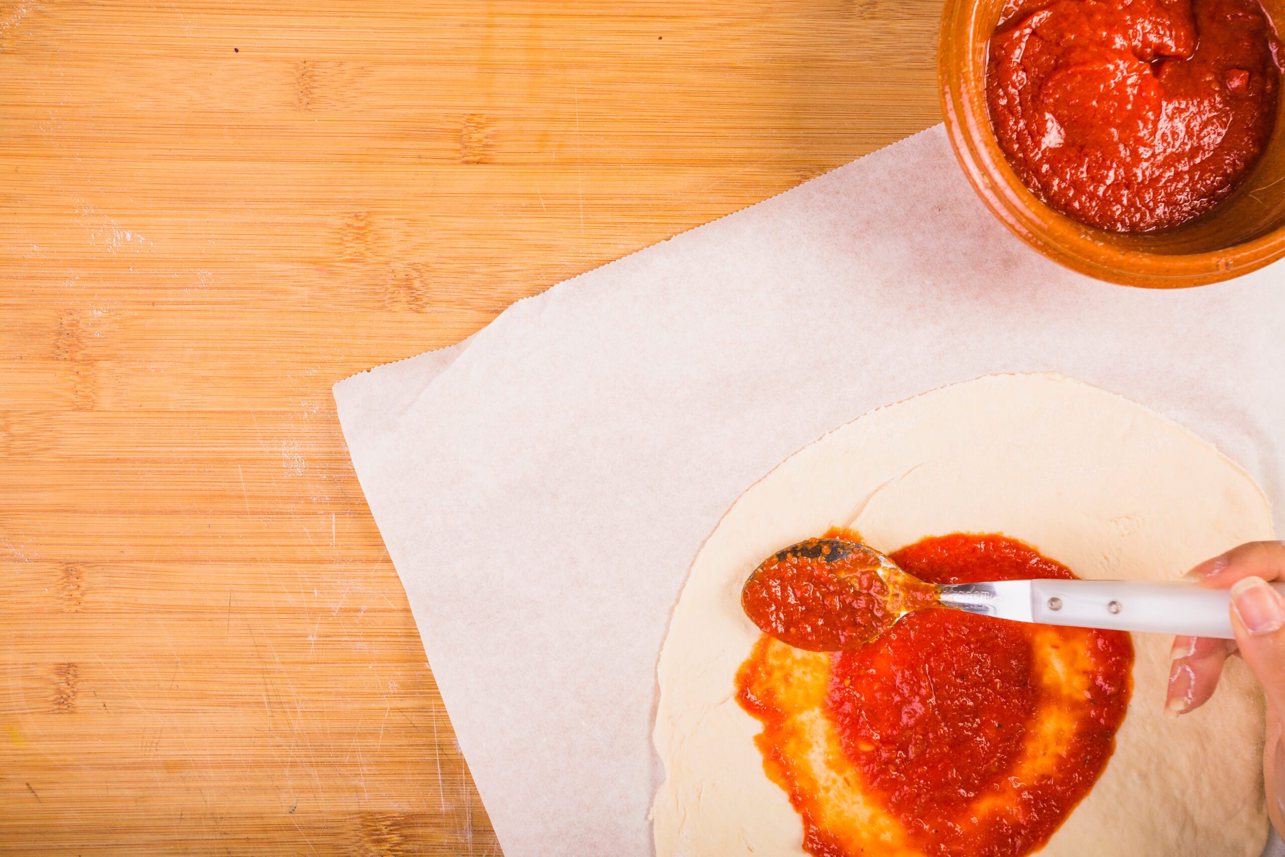 Sos de roșii pentru pizza italiană aplicat pe aluat pufos